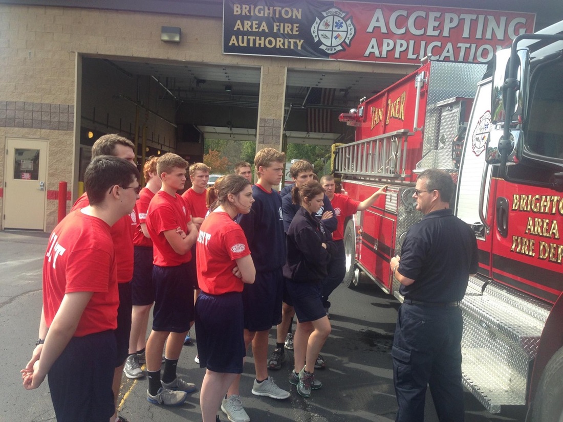 Students at fire hall examining fire truck