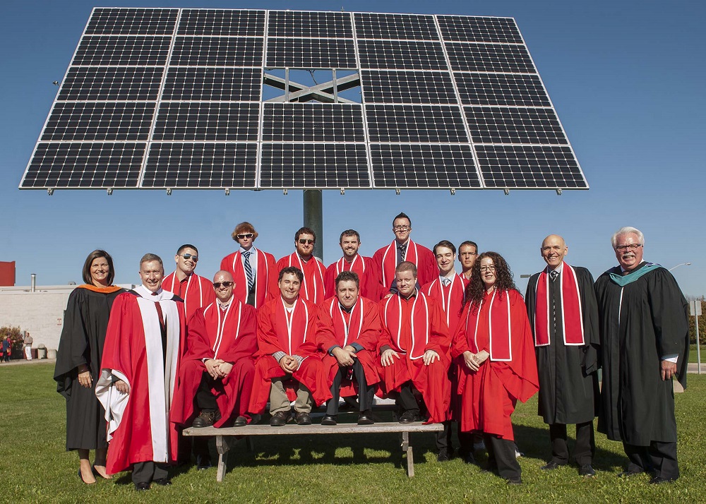 College grads and a solar panel