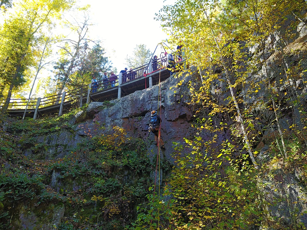 climbers at the top of a steep cliff