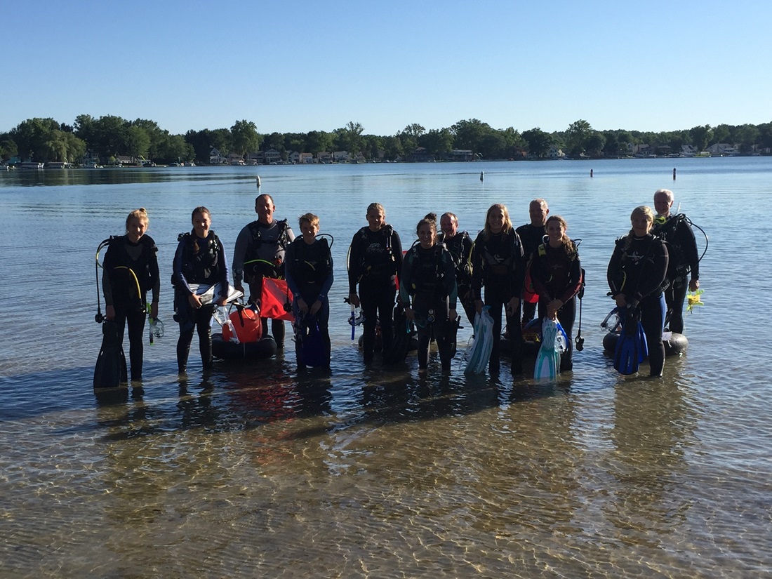 student group wearing wetsuits in shallow water