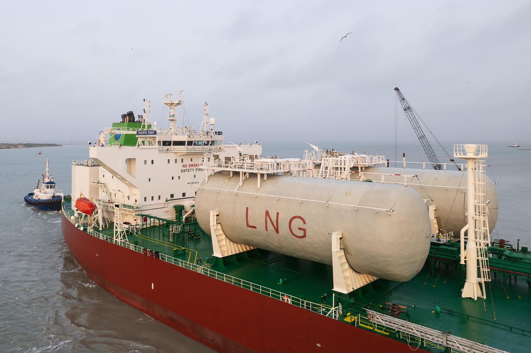 LNG tanker being steered by tug