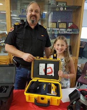 Girl and firefighter with defibrillator