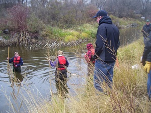 students collecting water samples in a marsh