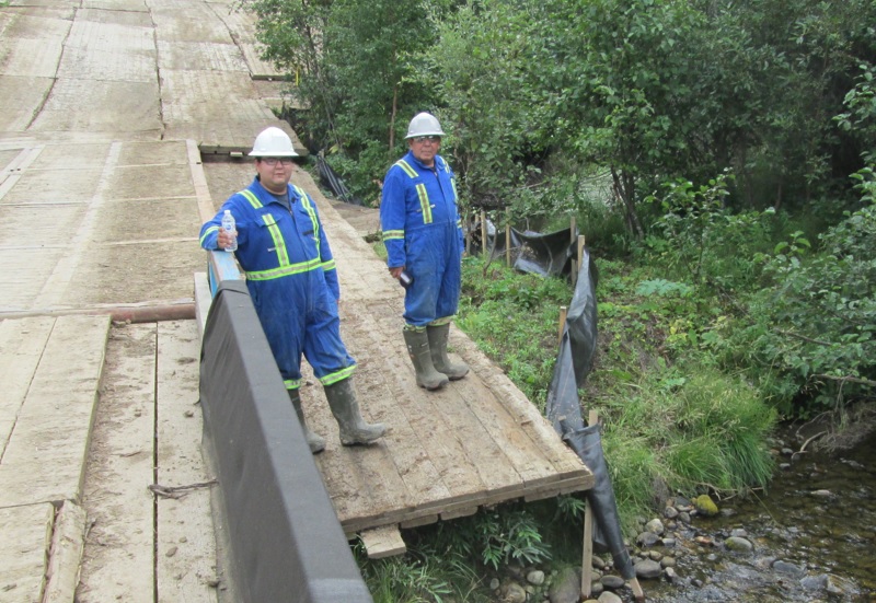 People in safety suits standing on a bridge