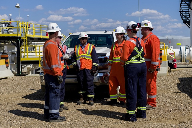 Employees wearing safety gear at a tank farm