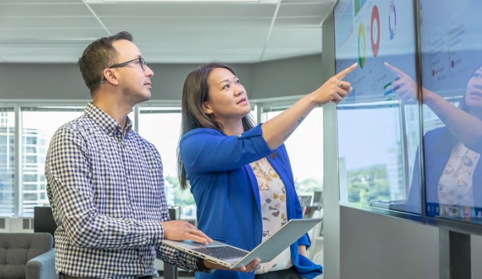 People looking at a large computer screen