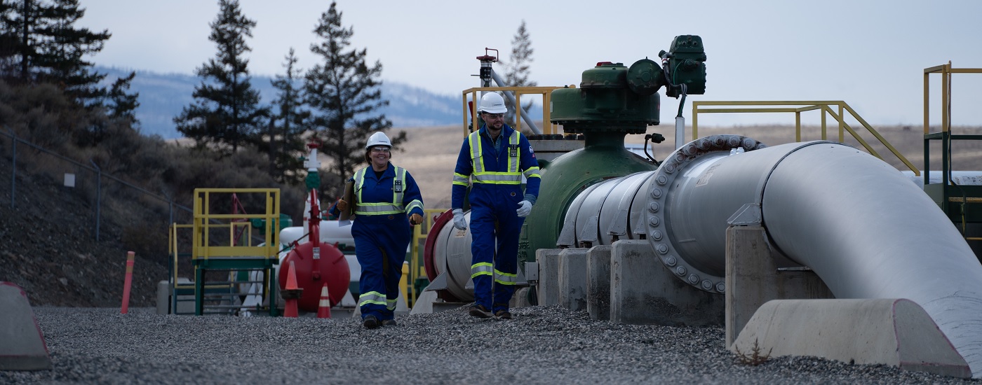 Two workers examining a pipe