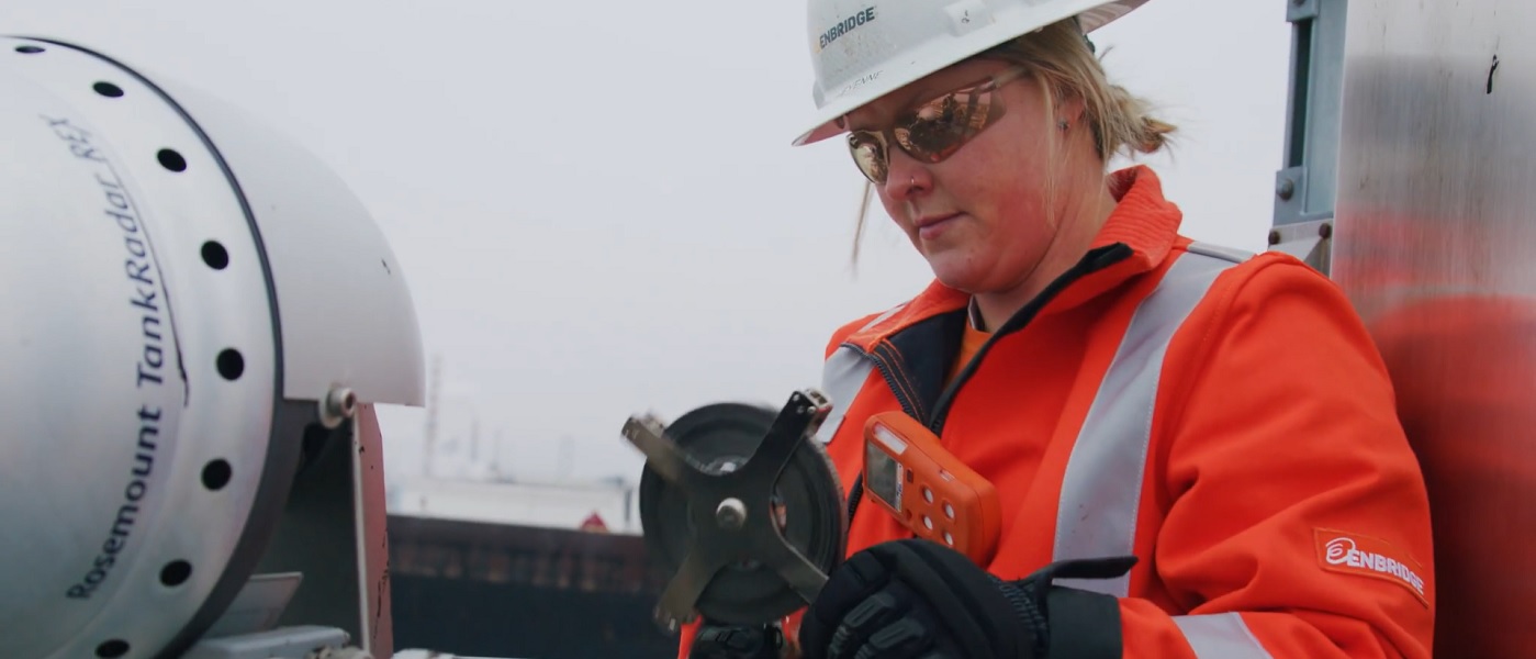 Woman in hardhat and safety gear doing maintenance work on pipeline