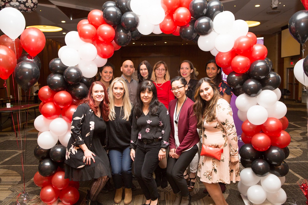 People surrounded by red white and black balloons