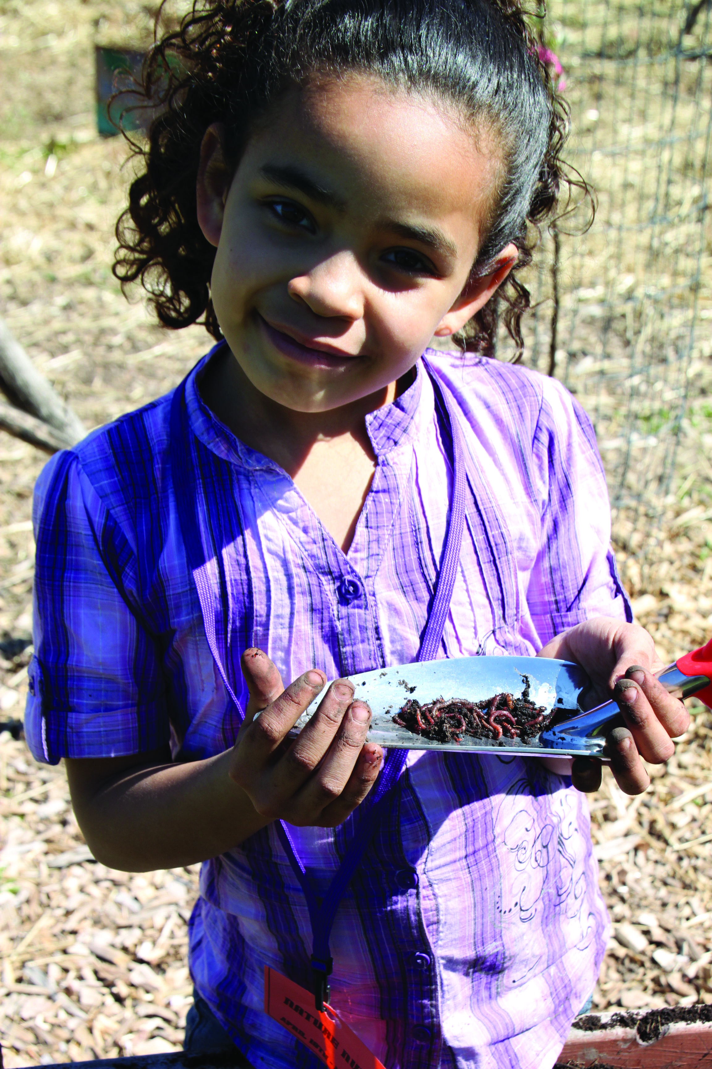 Child holding spade for worms