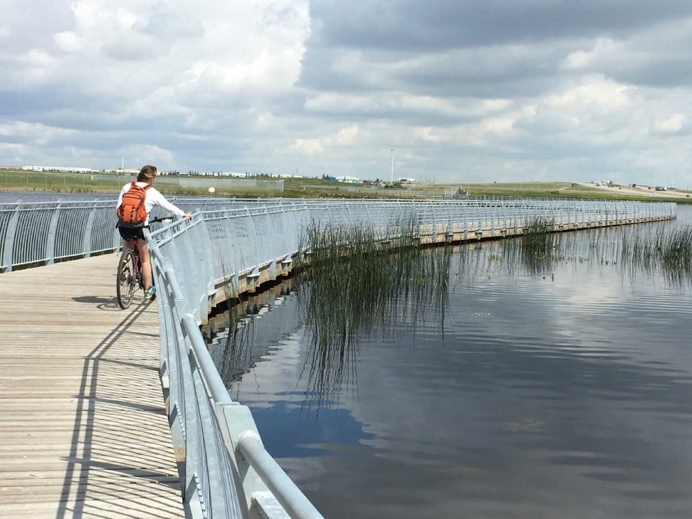 Cyclist on boardwalk over water