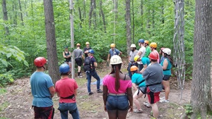 People in climbing gear outside in a forest