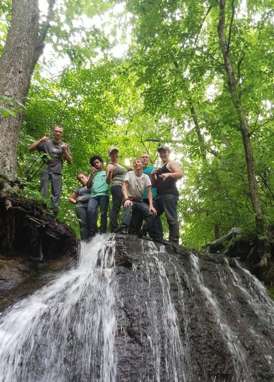 Kids at the top of a waterfall