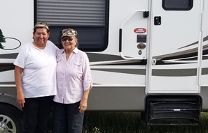 Two women beside an RV trailer