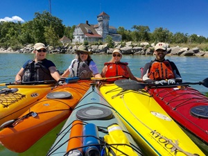 Four people in colored kayaks