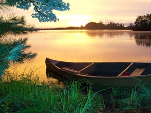 Canoe on lakeshore at sunset