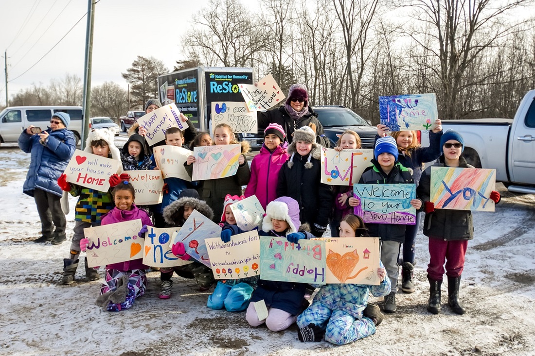 Children holding welcome signs