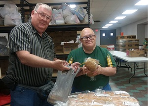Two people making a food hamper