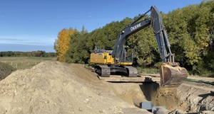 Excavator digging in pipe trench