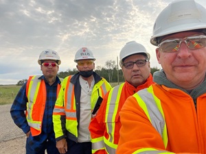 Pipeline workers in safety vests standing for a group photo