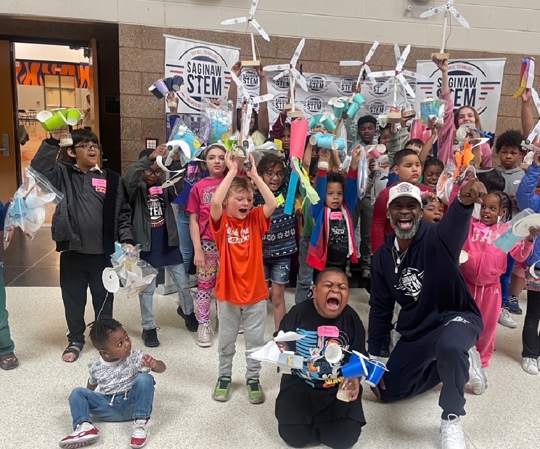 Kids holding up small electric windmills they made.