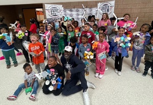 Kids holding up small electric windmills they made.