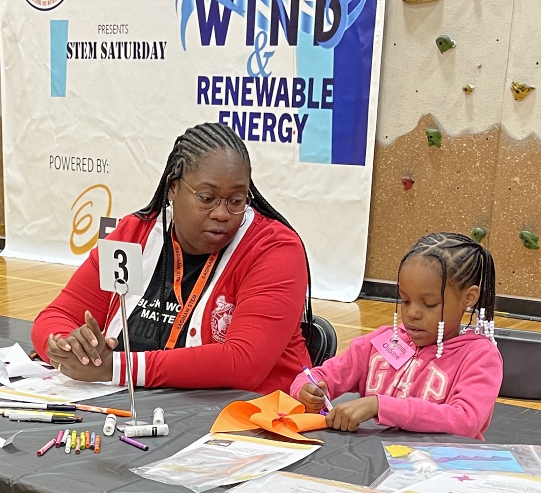 Adult and child at a table working on a windmill
