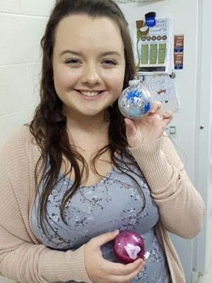 teen displaying Christmas ornament