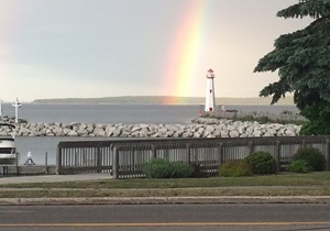 Pier and lighthouse with rainbow in background