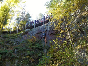 climbers at the top of a steep cliff