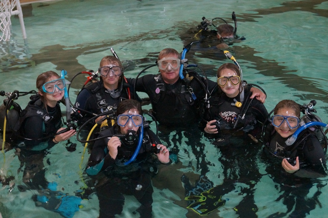 students learning scuba diving in a swimming pool
