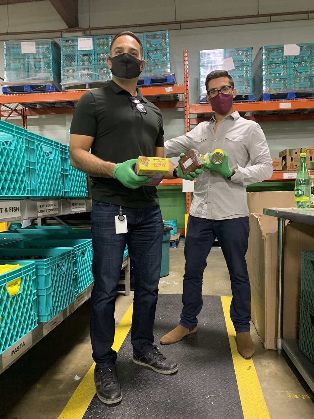 Two men holding up food packages