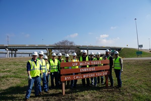 tree planters gathered around a Call 811 sign