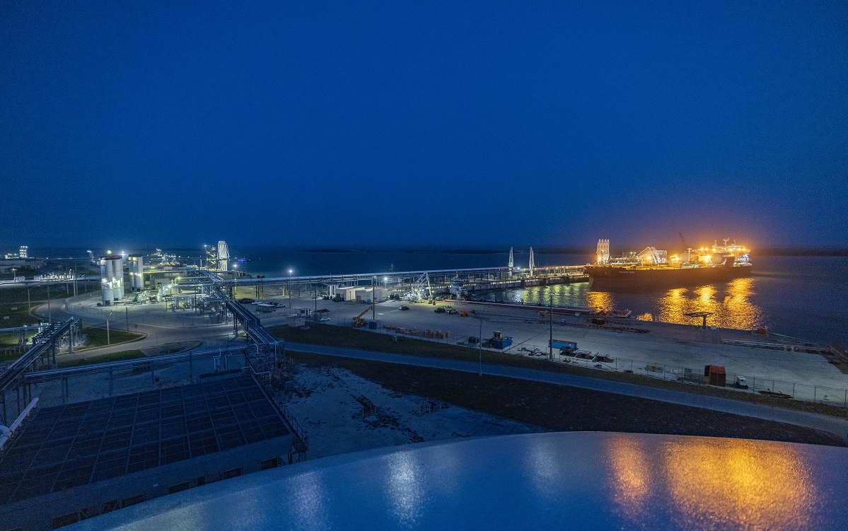 Large lit ship docked at a port