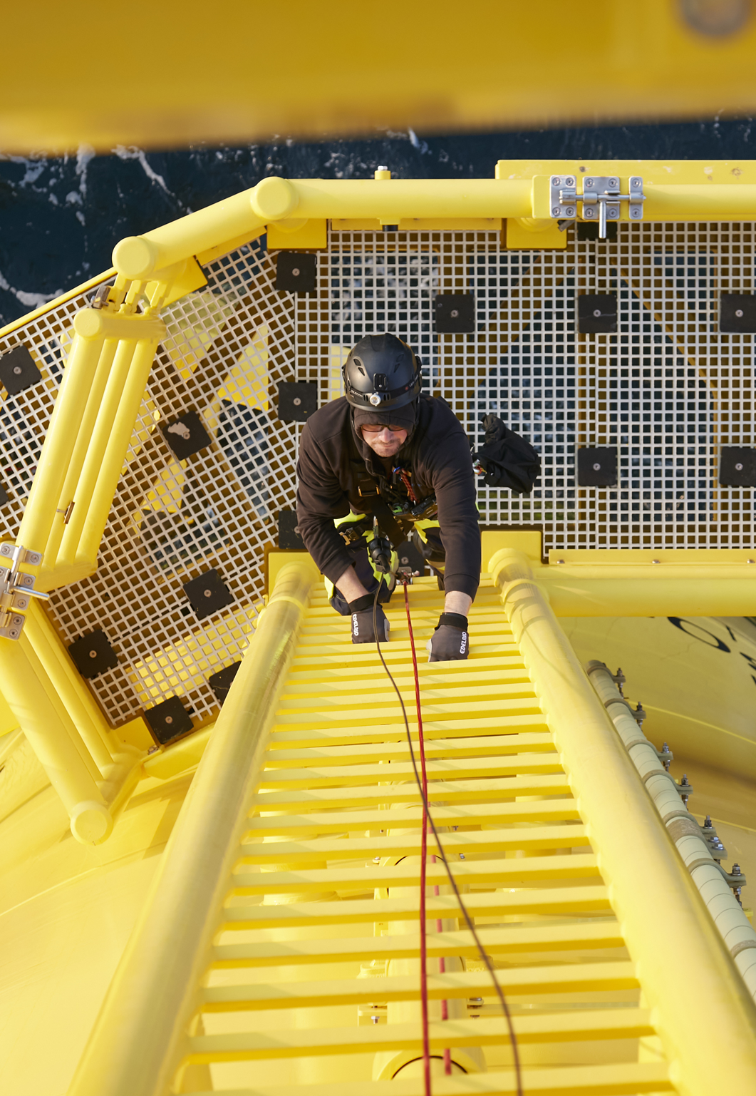 Worker climbing yellow ladder