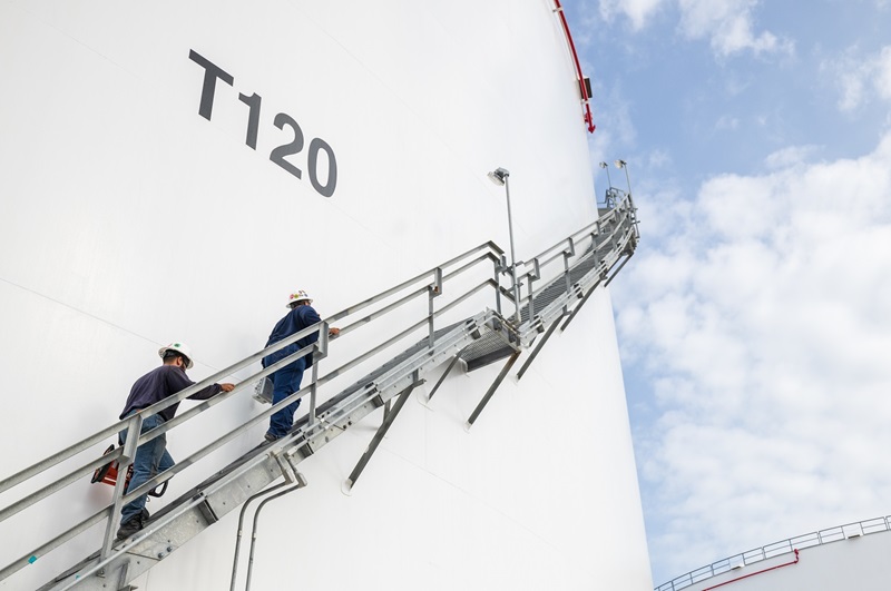 Workers walking up a tank ladder