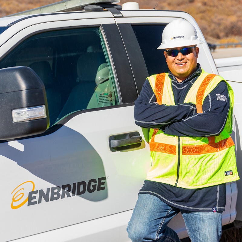 Worker in hardhat beside truck