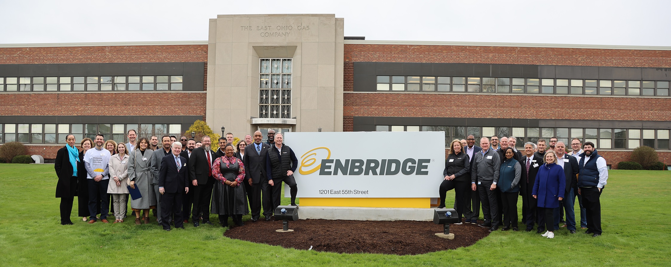 Large group of people in front of a building with Enbridge sign