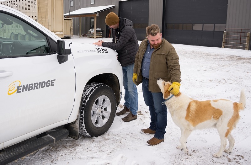 Man petting a dog beside a truck