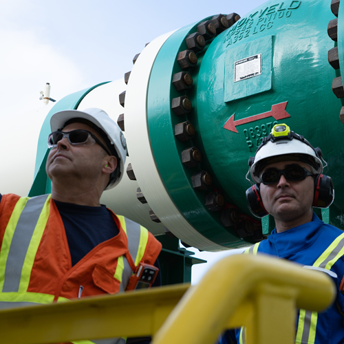 Two workers inf front of a big pipe