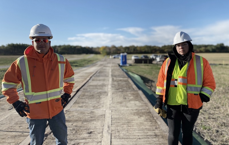 Two people in safety gear standing in a field