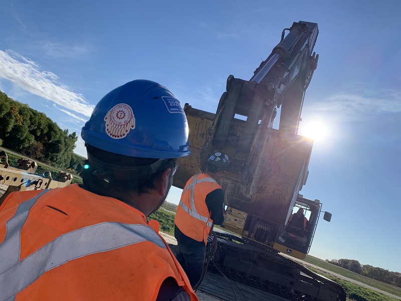 Workers in hardhats and a bulldozer