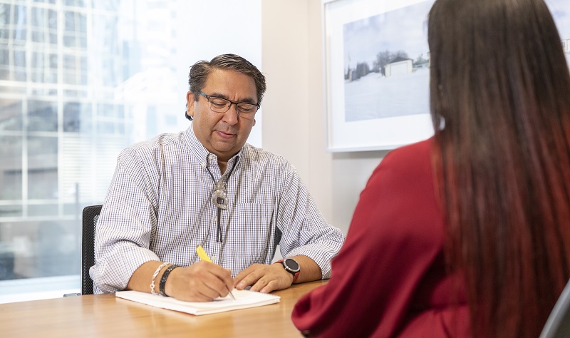 Man at desk interviewing job candidate
