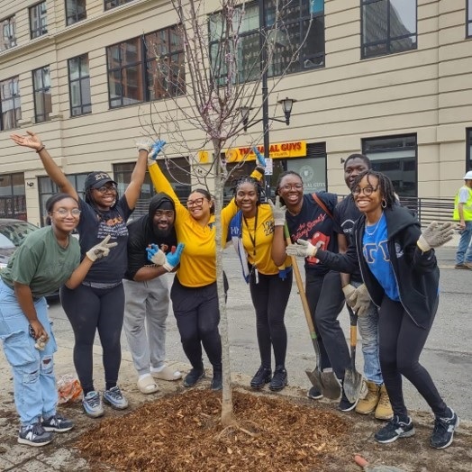 Young women celebrating after planting a tree