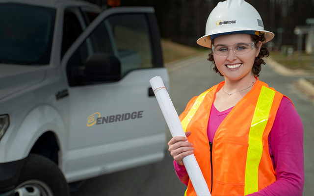 Woman in safety gear with engineering map