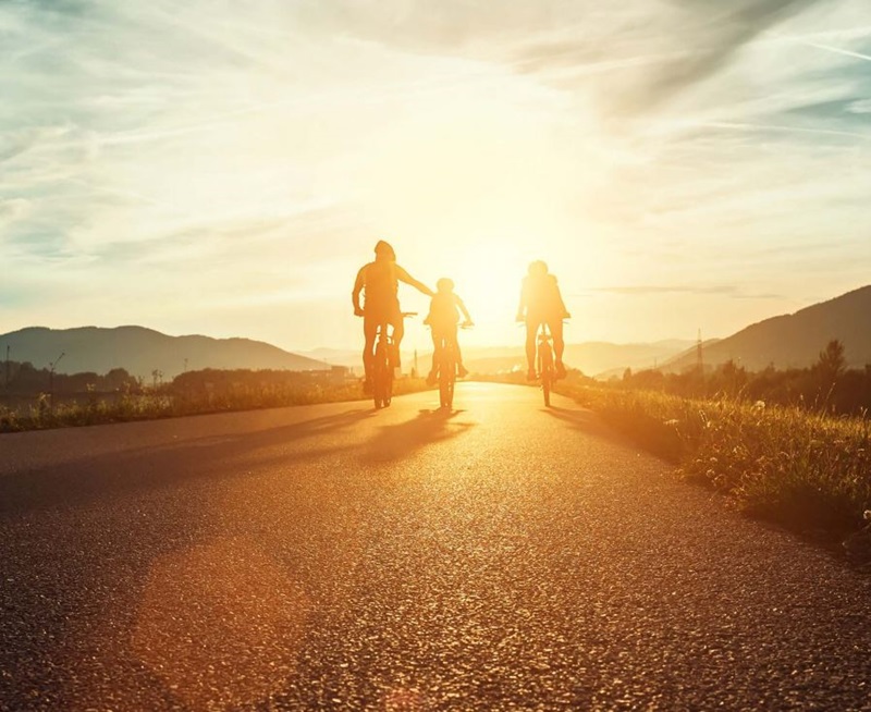 Family riding bicycles at sunset