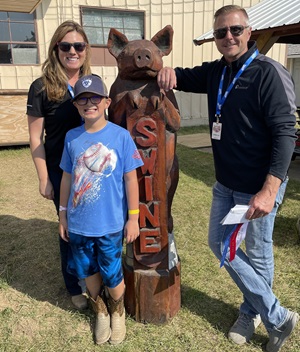 Teenage 4-H winner with a wood statue of a pig