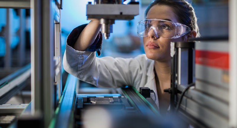 Female engineer working lathe