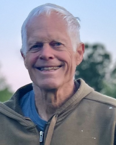 man standing in field at sunset