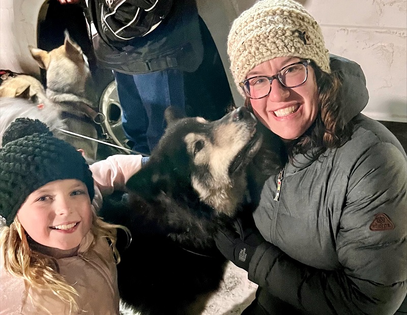 Woman and young girl with a sled dog